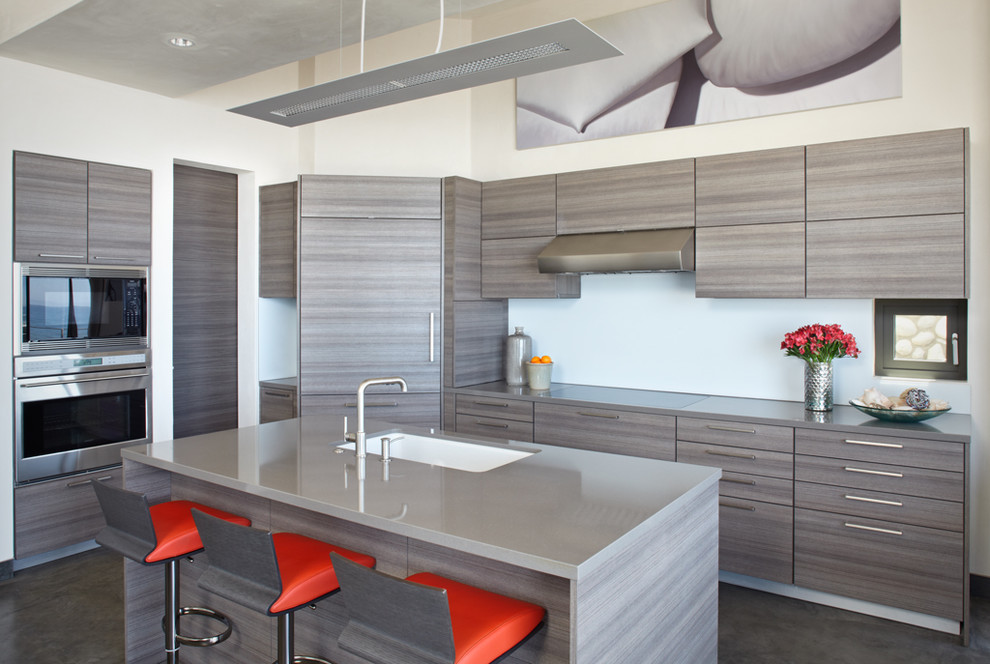 Moderne Küche in L-Form mit Unterbauwaschbecken, flächenbündigen Schrankfronten, hellen Holzschränken, Küchengeräten aus Edelstahl und Kücheninsel in Santa Barbara