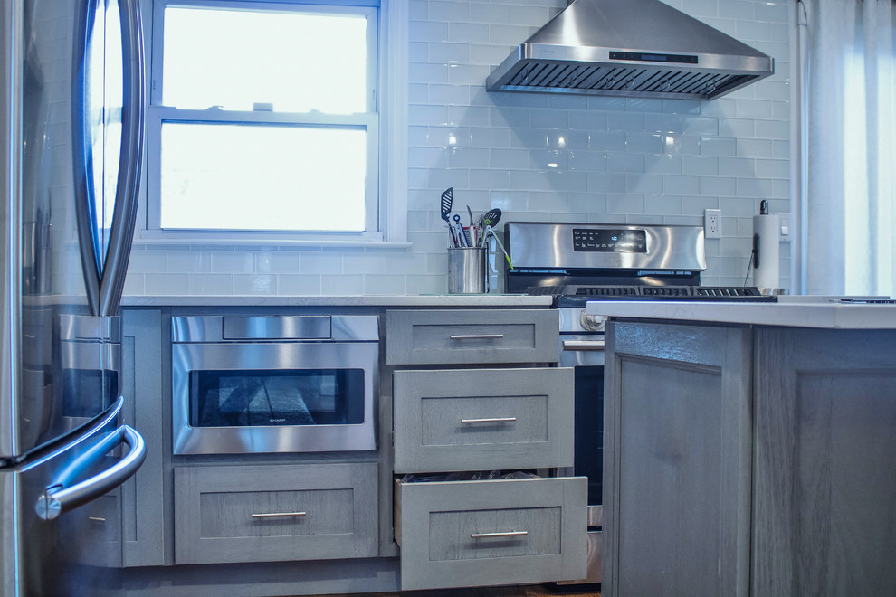 Esempio di una cucina classica con lavello sottopiano, ante in stile shaker, ante grigie, top in quarzo composito, paraspruzzi grigio, paraspruzzi con piastrelle di vetro e elettrodomestici in acciaio inossidabile