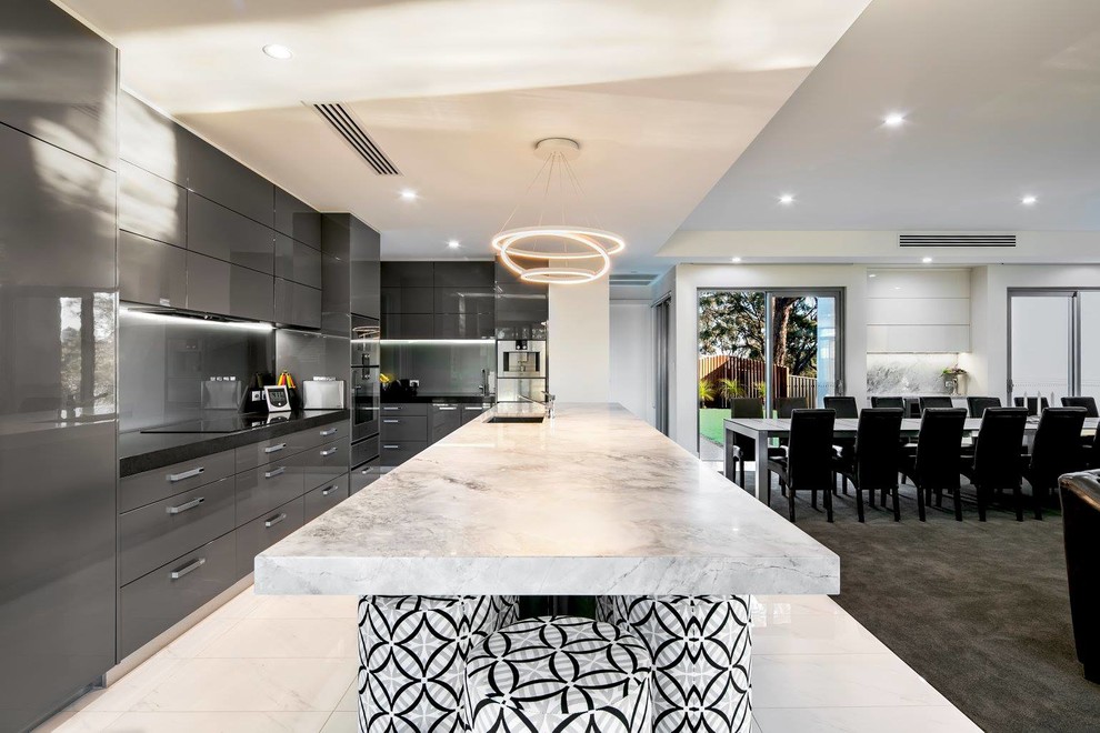 Eat-in kitchen - large contemporary galley porcelain tile and white floor eat-in kitchen idea in Adelaide with a drop-in sink, brown cabinets, quartz countertops, green backsplash, glass tile backsplash, stainless steel appliances, an island, louvered cabinets and gray countertops