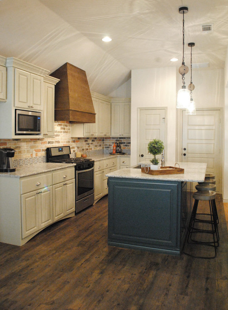 Bild på ett mellanstort vintage l-kök, med en rustik diskho, luckor med infälld panel, beige skåp, granitbänkskiva, stänkskydd i cementkakel, rostfria vitvaror, vinylgolv och en köksö