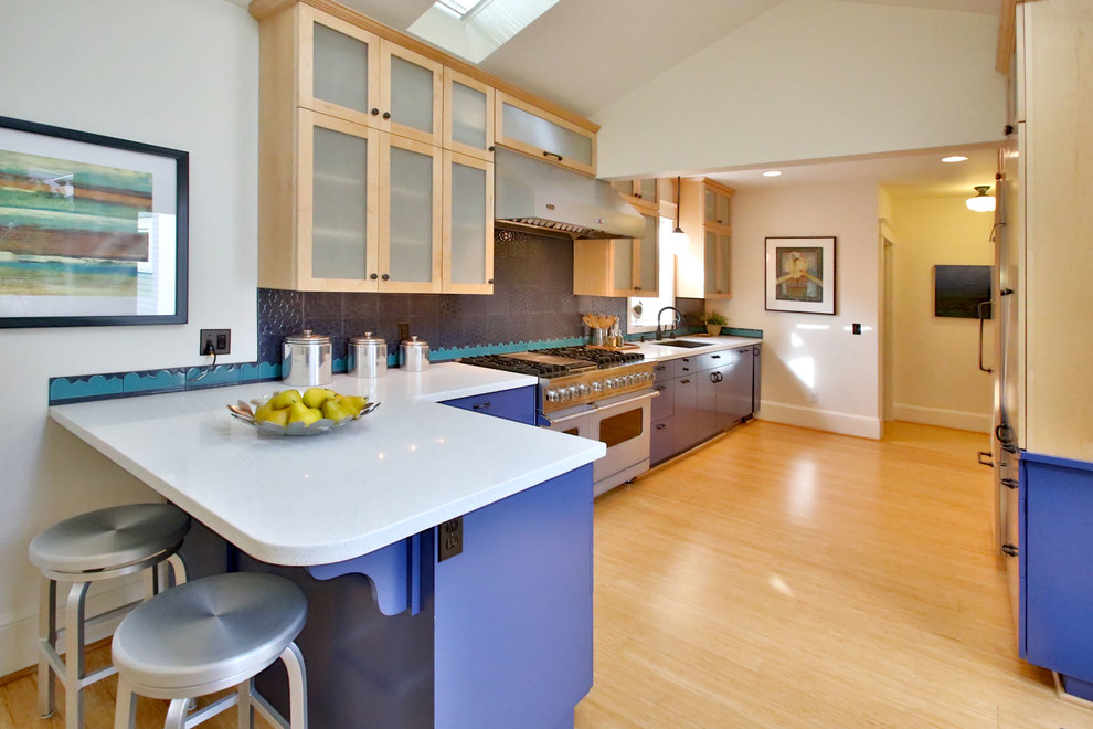 ポートランドにあるトランジショナルスタイルのおしゃれなキッチン (フラットパネル扉のキャビネット、中間色木目調キャビネット、黒いキッチンパネル、カラー調理設備) の写真