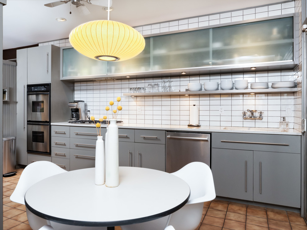 Eat-in kitchen - mid-sized mid-century modern galley ceramic tile eat-in kitchen idea in Birmingham with an undermount sink, flat-panel cabinets, gray cabinets, concrete countertops, white backsplash, ceramic backsplash, stainless steel appliances and no island