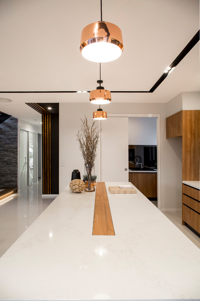 Inspiration for a mid-sized modern galley ceramic tile and beige floor open concept kitchen remodel in Brisbane with recessed-panel cabinets, medium tone wood cabinets, solid surface countertops, orange backsplash, mirror backsplash, paneled appliances and an island