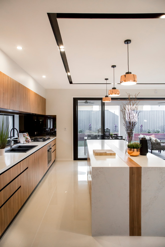 Mid-sized minimalist galley ceramic tile and beige floor open concept kitchen photo in Brisbane with a double-bowl sink, recessed-panel cabinets, medium tone wood cabinets, solid surface countertops, orange backsplash, mirror backsplash, paneled appliances and an island