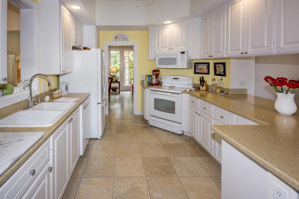 Mid-sized tuscan single-wall porcelain tile and beige floor eat-in kitchen photo in Other with a double-bowl sink, raised-panel cabinets, white cabinets and white appliances