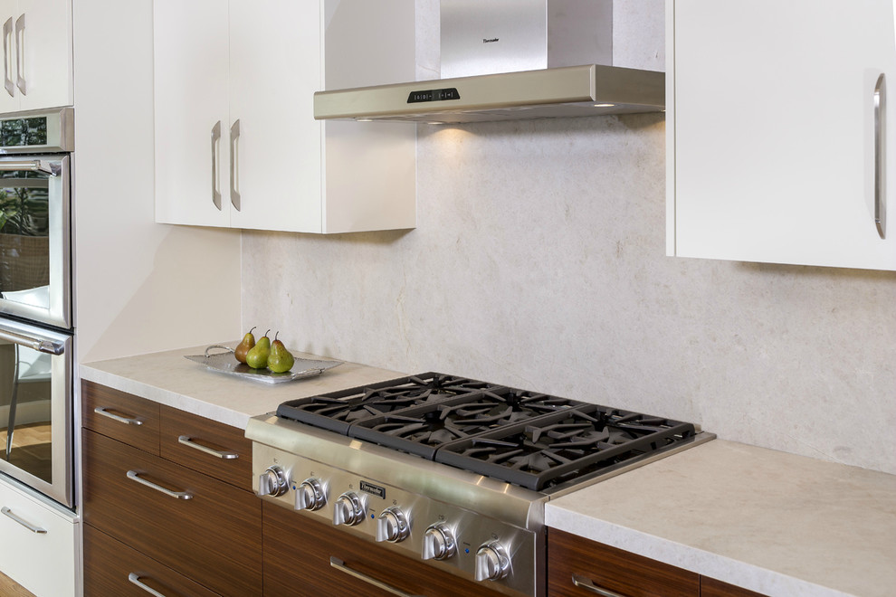 Esempio di una cucina moderna con lavello sottopiano, ante lisce, ante bianche, top in marmo, paraspruzzi bianco, paraspruzzi in lastra di pietra e elettrodomestici in acciaio inossidabile