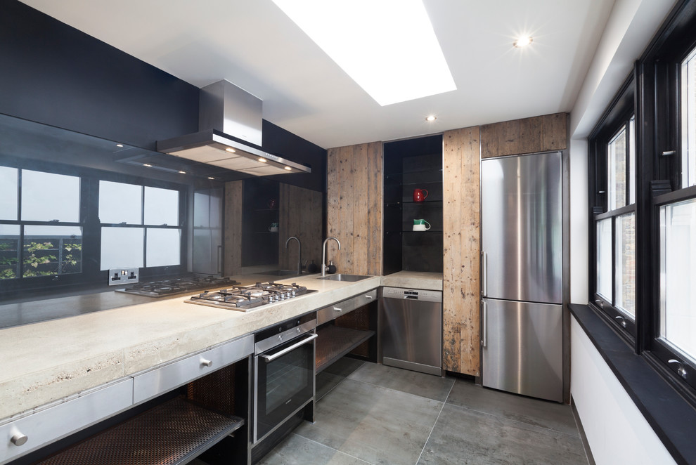 Modern inredning av ett avskilt, litet parallellkök, med en nedsänkt diskho, öppna hyllor, skåp i rostfritt stål, bänkskiva i betong, svart stänkskydd, glaspanel som stänkskydd, rostfria vitvaror, betonggolv och en köksö