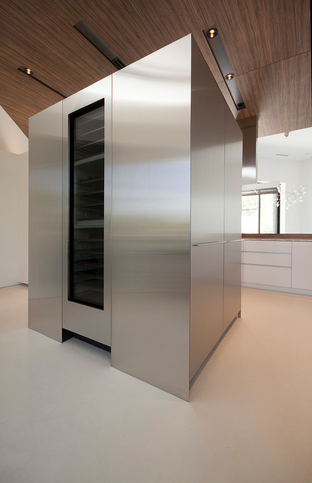 Idéer för ett modernt kök, med släta luckor, skåp i rostfritt stål, marmorbänkskiva, rostfria vitvaror, betonggolv, en köksö och en undermonterad diskho