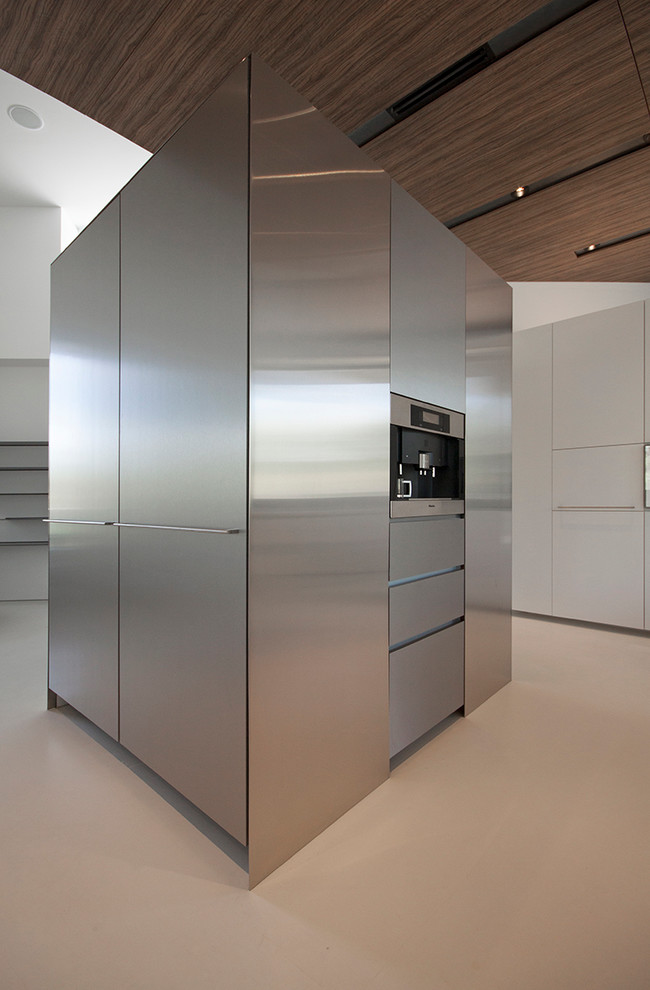 Inspiration för moderna kök, med släta luckor, skåp i rostfritt stål, marmorbänkskiva, rostfria vitvaror, betonggolv, en köksö och en undermonterad diskho