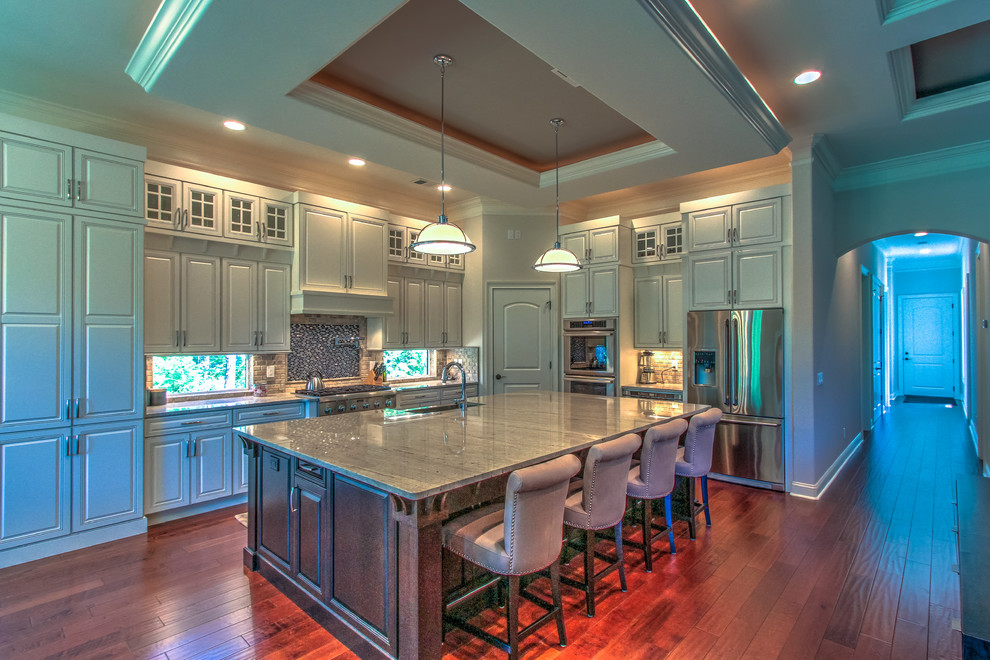 Large transitional l-shaped medium tone wood floor and red floor eat-in kitchen photo in Atlanta with a single-bowl sink, raised-panel cabinets, white cabinets, granite countertops, stainless steel appliances, window backsplash and an island