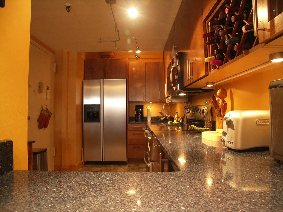 ニューヨークにある小さなコンテンポラリースタイルのおしゃれなキッチン (シングルシンク、フラットパネル扉のキャビネット、中間色木目調キャビネット、クオーツストーンカウンター、オレンジのキッチンパネル、シルバーの調理設備、セラミックタイルの床、アイランドなし) の写真