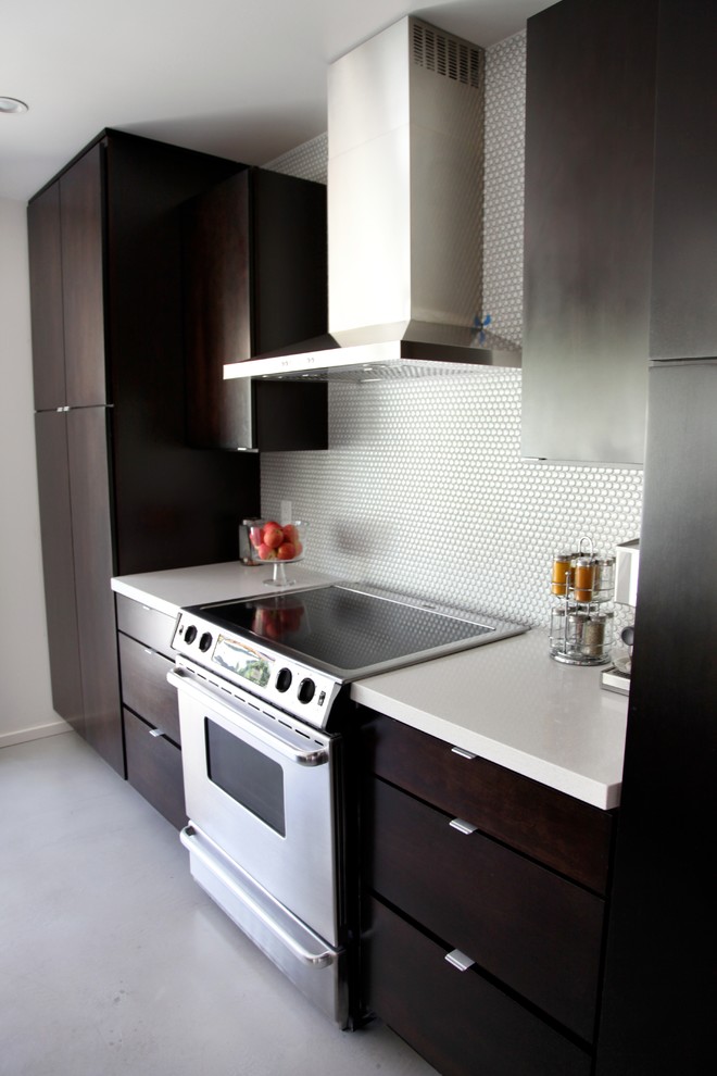 Modern inredning av ett avskilt, mellanstort l-kök, med en undermonterad diskho, släta luckor, skåp i mörkt trä, bänkskiva i koppar, vitt stänkskydd, stänkskydd i mosaik, rostfria vitvaror, betonggolv och en köksö