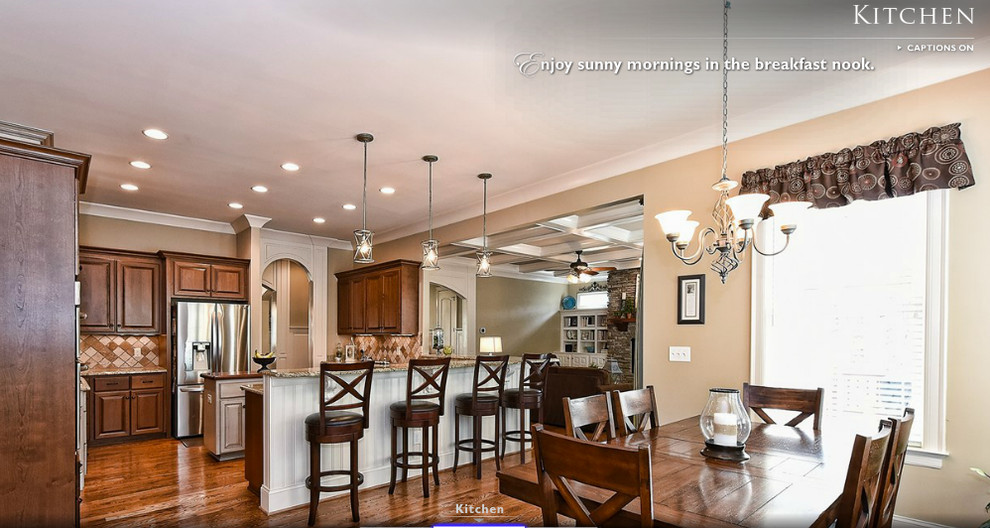 Large classic u-shaped kitchen/diner in Charlotte with an island, raised-panel cabinets, medium wood cabinets, granite worktops, beige splashback, stone tiled splashback, stainless steel appliances, a submerged sink and medium hardwood flooring.