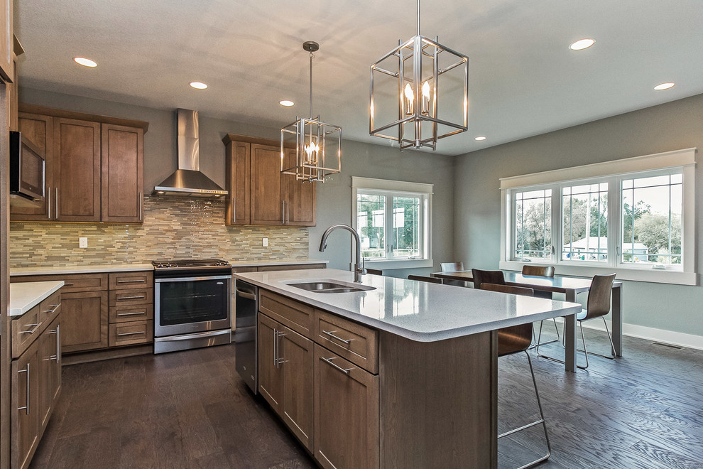 Example of a large arts and crafts l-shaped medium tone wood floor eat-in kitchen design in Other with an undermount sink, shaker cabinets, distressed cabinets, quartz countertops, multicolored backsplash, stone tile backsplash, stainless steel appliances and an island