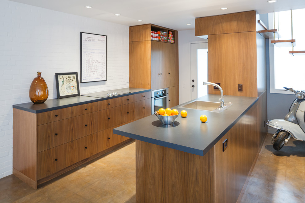 Photo of a contemporary galley kitchen in Dallas with a built-in sink, flat-panel cabinets, medium wood cabinets and a breakfast bar.