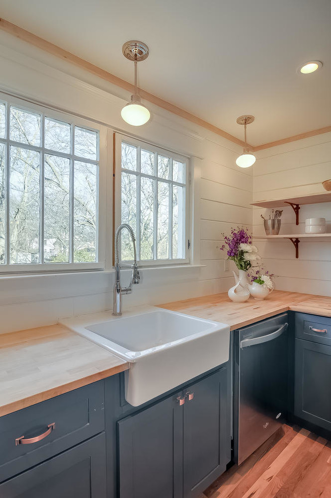 Mid-sized cottage chic u-shaped light wood floor eat-in kitchen photo in Nashville with a farmhouse sink, shaker cabinets, blue cabinets, wood countertops, white backsplash and stainless steel appliances