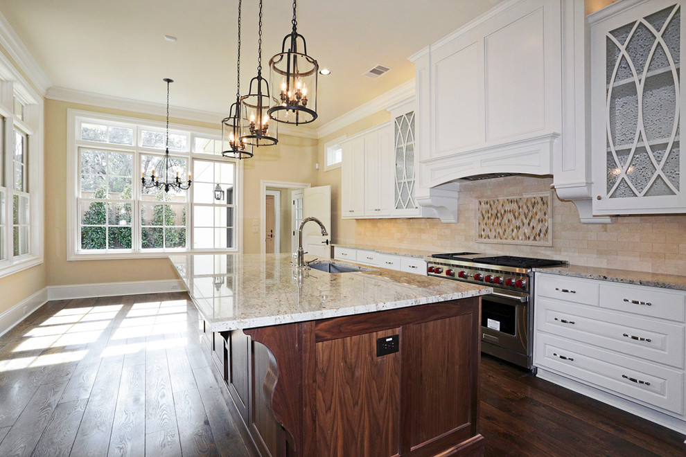 Exempel på ett klassiskt kök, med en undermonterad diskho, skåp i shakerstil, vita skåp, granitbänkskiva, beige stänkskydd, stänkskydd i stenkakel, rostfria vitvaror, mörkt trägolv och en köksö