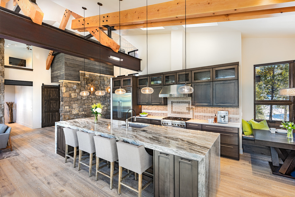 Offene Rustikale Küche mit Unterbauwaschbecken, dunklen Holzschränken, Küchengeräten aus Edelstahl, hellem Holzboden und Kücheninsel in Denver