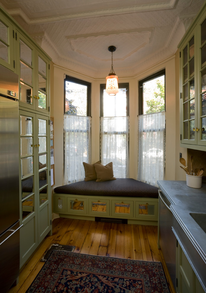Mittelgroße Landhaus Wohnküche ohne Insel in L-Form mit integriertem Waschbecken, Glasfronten, grünen Schränken und hellem Holzboden in New York