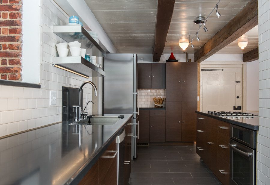Large transitional galley porcelain tile eat-in kitchen photo in Boston with an undermount sink, flat-panel cabinets, dark wood cabinets, concrete countertops, white backsplash, subway tile backsplash, stainless steel appliances and an island