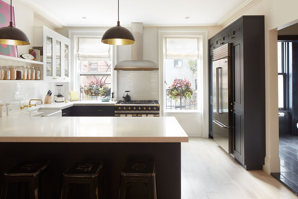 Inspiration pour une cuisine traditionnelle en U avec un évier de ferme, un placard avec porte à panneau encastré, une crédence blanche, une crédence en carrelage métro, parquet clair et une péninsule.