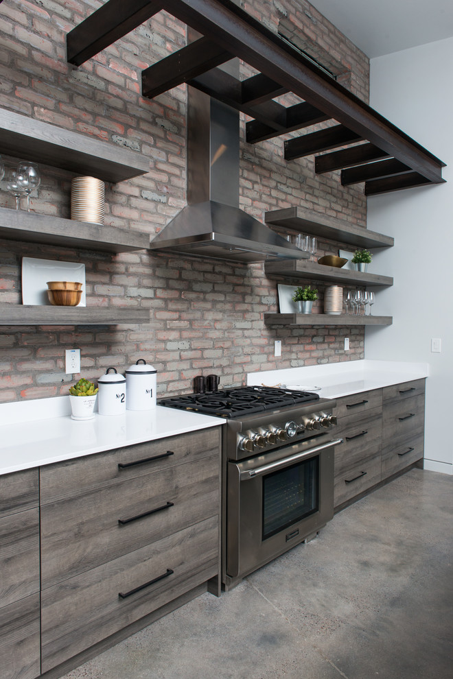 Mid-sized urban l-shaped concrete floor and gray floor open concept kitchen photo in Phoenix with an undermount sink, flat-panel cabinets, medium tone wood cabinets, quartzite countertops, red backsplash, brick backsplash, stainless steel appliances, an island and white countertops