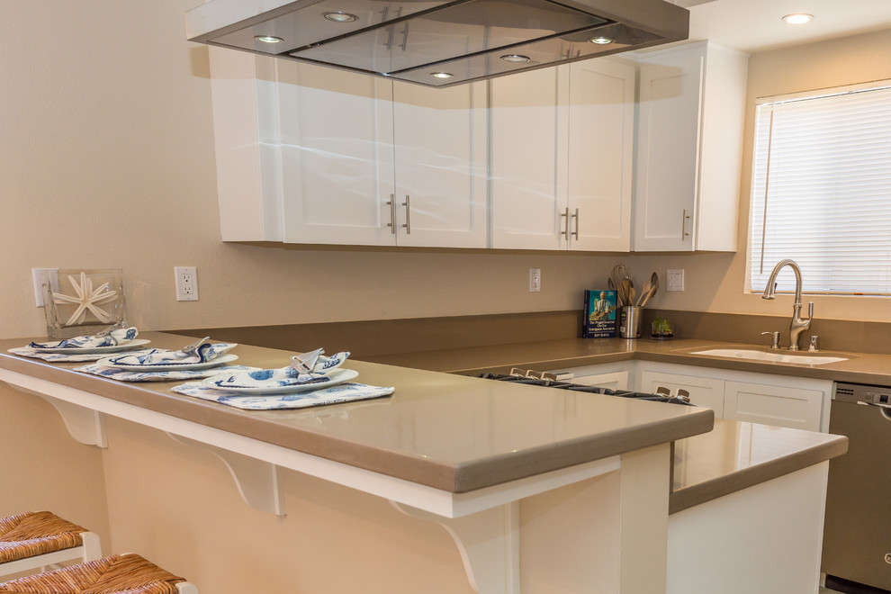 Modern inredning av ett grå grått kök, med en nedsänkt diskho, skåp i shakerstil, vita skåp, träbänkskiva, grått stänkskydd, rostfria vitvaror, marmorgolv, en halv köksö och beiget golv