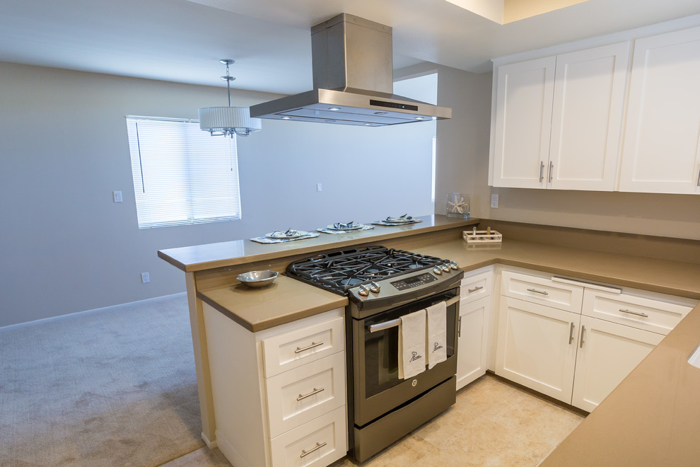 Foto på ett funkis grå kök, med en nedsänkt diskho, skåp i shakerstil, vita skåp, träbänkskiva, grått stänkskydd, rostfria vitvaror, marmorgolv, en halv köksö och beiget golv