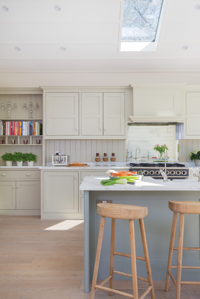 Große Klassische Wohnküche mit Schrankfronten im Shaker-Stil, Kücheninsel, grünen Schränken, Marmor-Arbeitsplatte, Küchenrückwand in Grün, Rückwand aus Spiegelfliesen und hellem Holzboden in Surrey