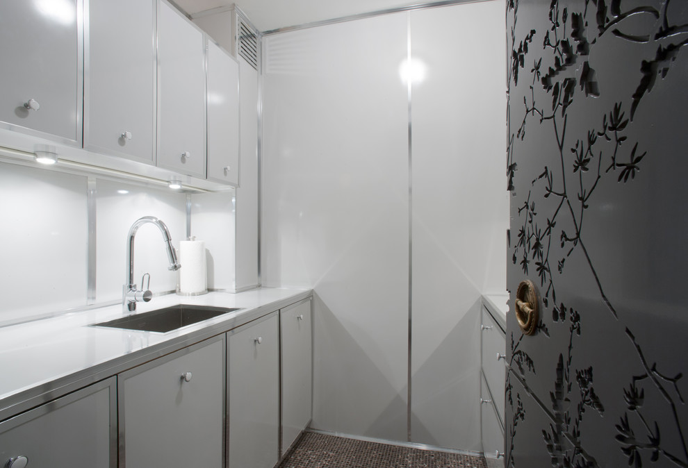 Zweizeilige, Kleine, Geschlossene Moderne Küche ohne Insel mit Einbauwaschbecken, weißen Schränken, Küchenrückwand in Weiß, weißen Elektrogeräten und Schieferboden in New York