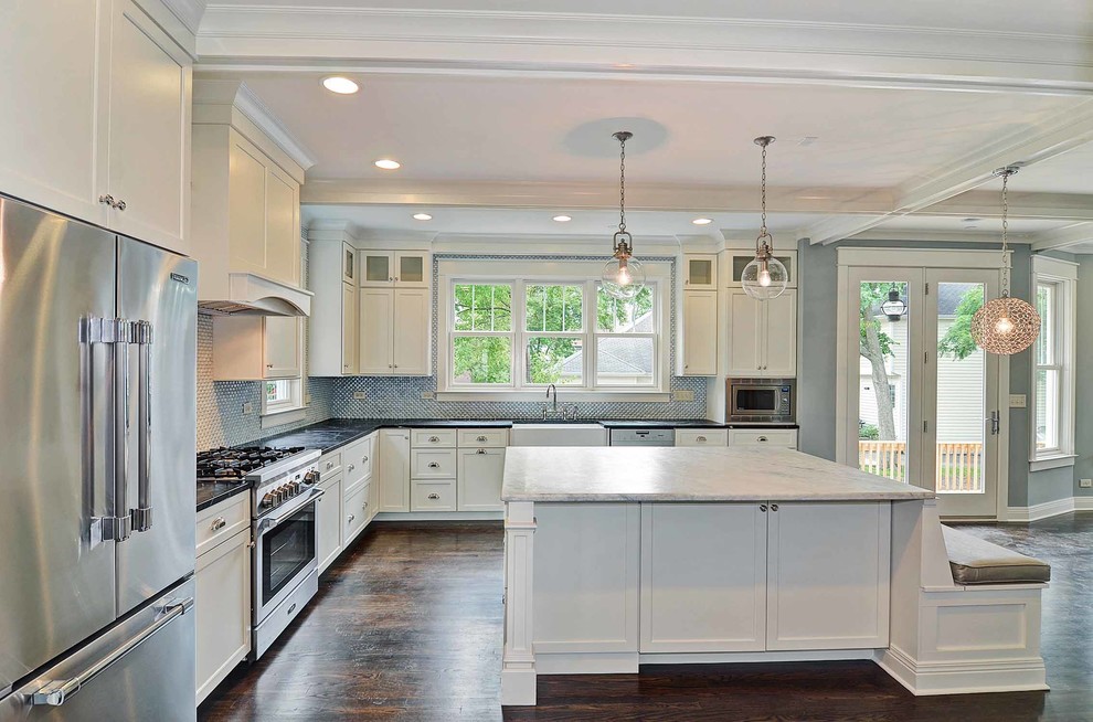 Large transitional u-shaped dark wood floor and brown floor eat-in kitchen photo in Chicago with a farmhouse sink, shaker cabinets, white cabinets, stainless steel appliances, an island, soapstone countertops, metallic backsplash and mosaic tile backsplash