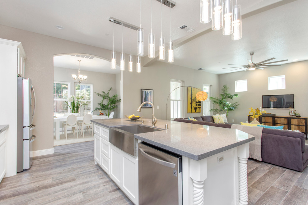Inspiration for a large transitional galley porcelain tile and gray floor open concept kitchen remodel in Sacramento with a farmhouse sink, shaker cabinets, white backsplash, glass tile backsplash, stainless steel appliances and an island