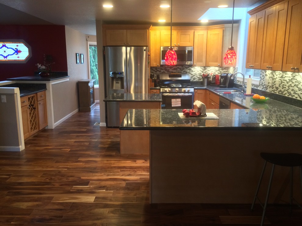 Large elegant l-shaped medium tone wood floor eat-in kitchen photo in Seattle with an undermount sink, shaker cabinets, medium tone wood cabinets, granite countertops, multicolored backsplash, glass tile backsplash, stainless steel appliances and an island