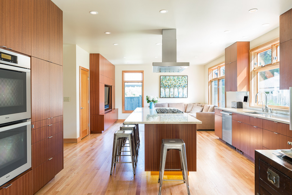 Inspiration for a mid-sized modern u-shaped light wood floor eat-in kitchen remodel in Seattle with an undermount sink, flat-panel cabinets, medium tone wood cabinets, quartz countertops, stainless steel appliances and an island