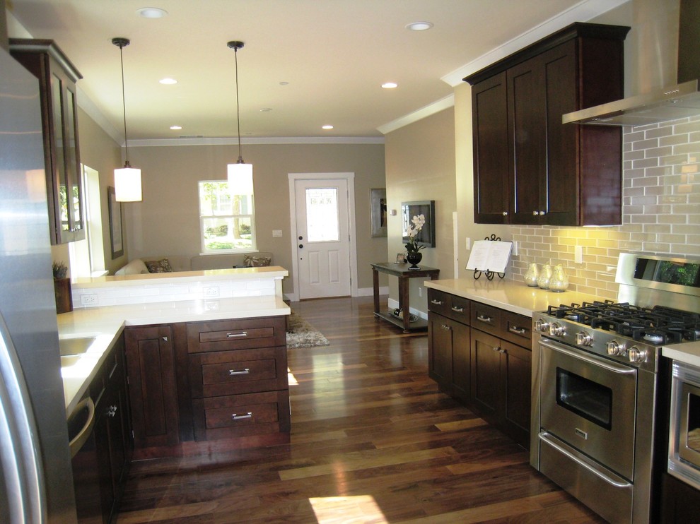 Exempel på ett litet modernt kök, med en dubbel diskho, luckor med infälld panel, bruna skåp, bänkskiva i koppar, vitt stänkskydd, stänkskydd i tunnelbanekakel, rostfria vitvaror och mörkt trägolv