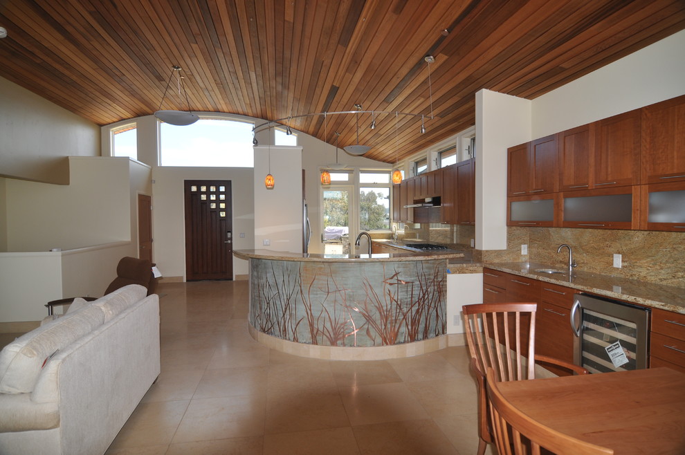 Пример оригинального дизайна: кухня-гостиная среднего размера в современном стиле с двойной мойкой, фасадами в стиле шейкер, фасадами цвета дерева среднего тона, гранитной столешницей, разноцветным фартуком, техникой из нержавеющей стали, полом из известняка и полуостровом