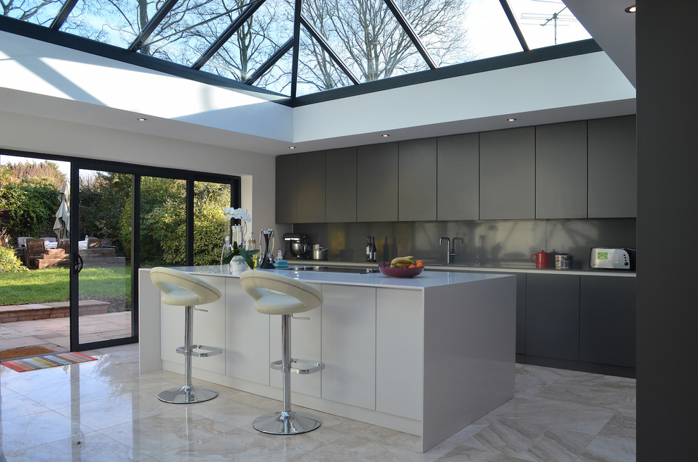 Cette image montre une cuisine design en L de taille moyenne avec un évier encastré, un placard à porte plane, îlot, un sol beige et plafond verrière.