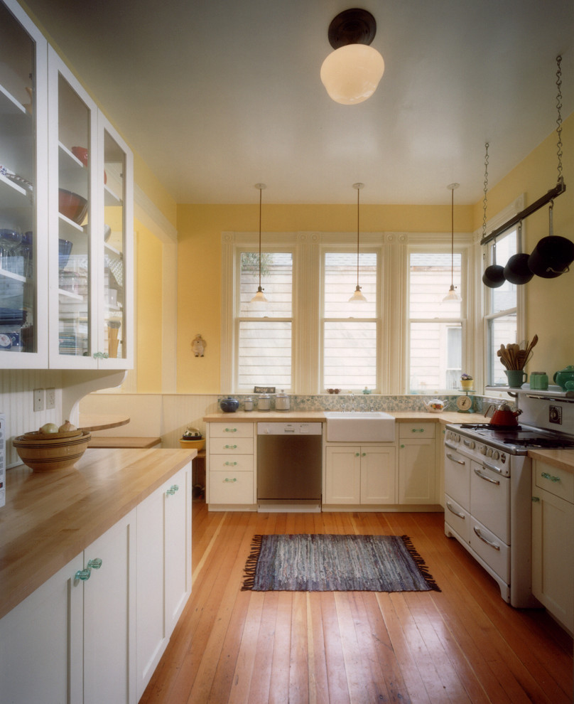 Modelo de cocina contemporánea sin isla con fregadero sobremueble, armarios estilo shaker, puertas de armario blancas, encimera de madera y suelo de madera en tonos medios