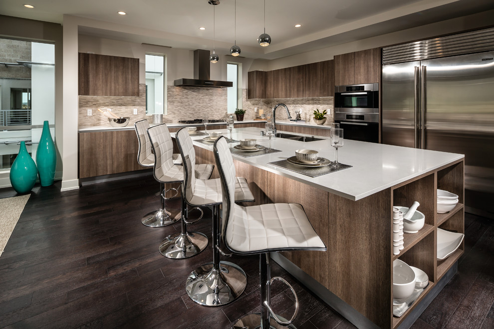 Design ideas for a large contemporary l-shaped open plan kitchen in Los Angeles with dark hardwood flooring, a double-bowl sink, flat-panel cabinets, dark wood cabinets, composite countertops, beige splashback, matchstick tiled splashback, stainless steel appliances and an island.