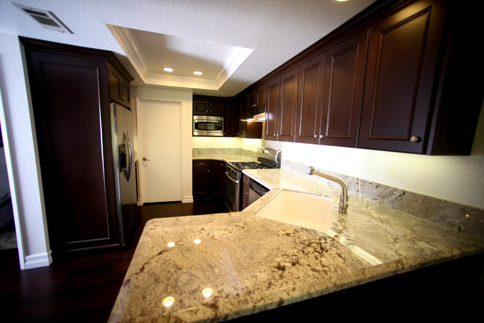 Example of a small transitional u-shaped dark wood floor eat-in kitchen design in Orange County with an undermount sink, recessed-panel cabinets, dark wood cabinets, granite countertops, stone slab backsplash, stainless steel appliances and no island