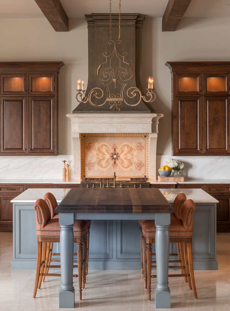 Foto på ett stort medelhavsstil kök, med en rustik diskho, luckor med upphöjd panel, skåp i mellenmörkt trä, vitt stänkskydd, stänkskydd i sten, integrerade vitvaror, en köksö, kalkstensgolv och träbänkskiva