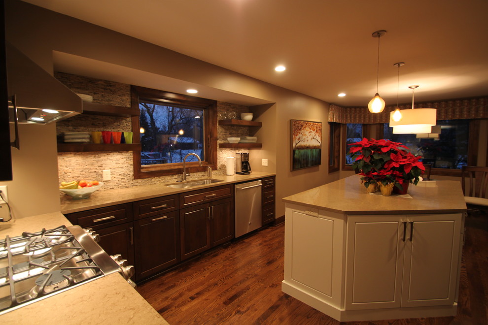 Foto på ett stort amerikanskt beige kök, med en undermonterad diskho, luckor med upphöjd panel, vita skåp, bänkskiva i kvarts, beige stänkskydd, stänkskydd i stenkakel, rostfria vitvaror, mörkt trägolv, en köksö och brunt golv