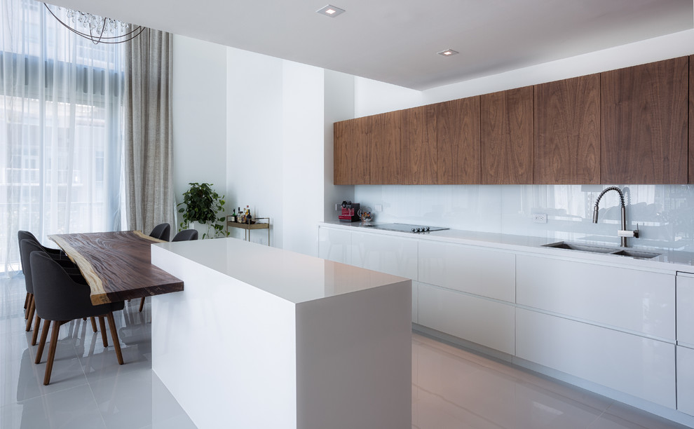 Стильный дизайн: параллельная кухня в современном стиле с обеденным столом, плоскими фасадами и белым фартуком - последний тренд