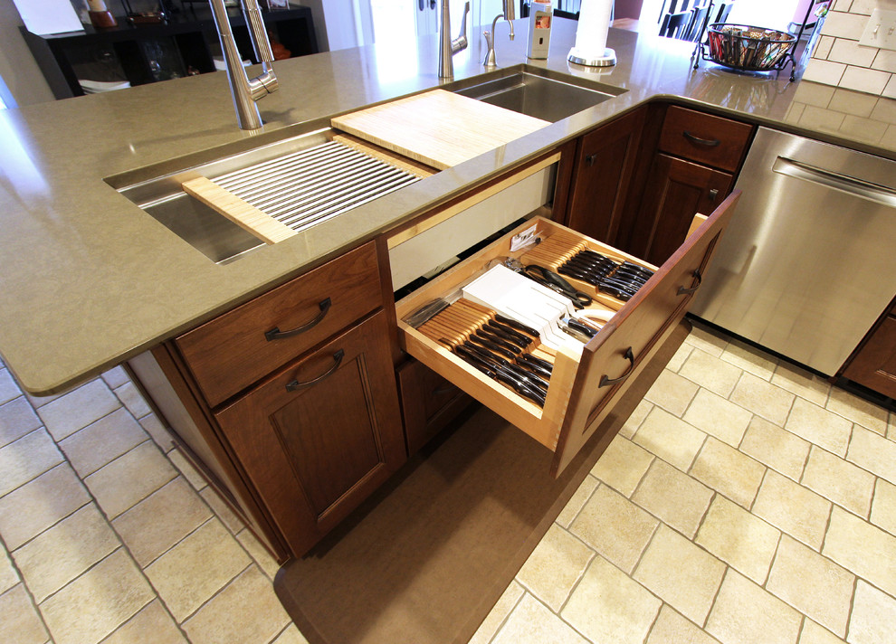Inspiration for a mid-sized transitional u-shaped eat-in kitchen remodel in Cleveland with an undermount sink, flat-panel cabinets, medium tone wood cabinets, quartz countertops, beige backsplash, limestone backsplash, stainless steel appliances and a peninsula
