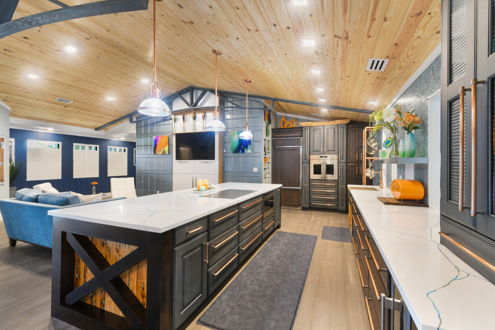マイアミにあるラグジュアリーな巨大なエクレクティックスタイルのおしゃれなキッチン (エプロンフロントシンク、レイズドパネル扉のキャビネット、青いキャビネット、人工大理石カウンター、青いキッチンパネル、ガラス板のキッチンパネル、シルバーの調理設備、竹フローリング、茶色い床、白いキッチンカウンター) の写真