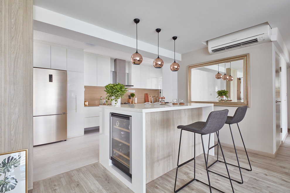 This is an example of a contemporary galley kitchen in Singapore with flat-panel cabinets, white cabinets, brown splashback, wood splashback, light hardwood flooring, grey floors and white worktops.