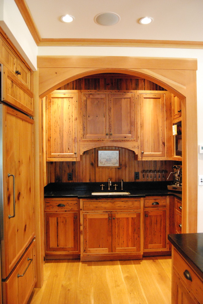 Aménagement d'une cuisine montagne avec un placard avec porte à panneau encastré.