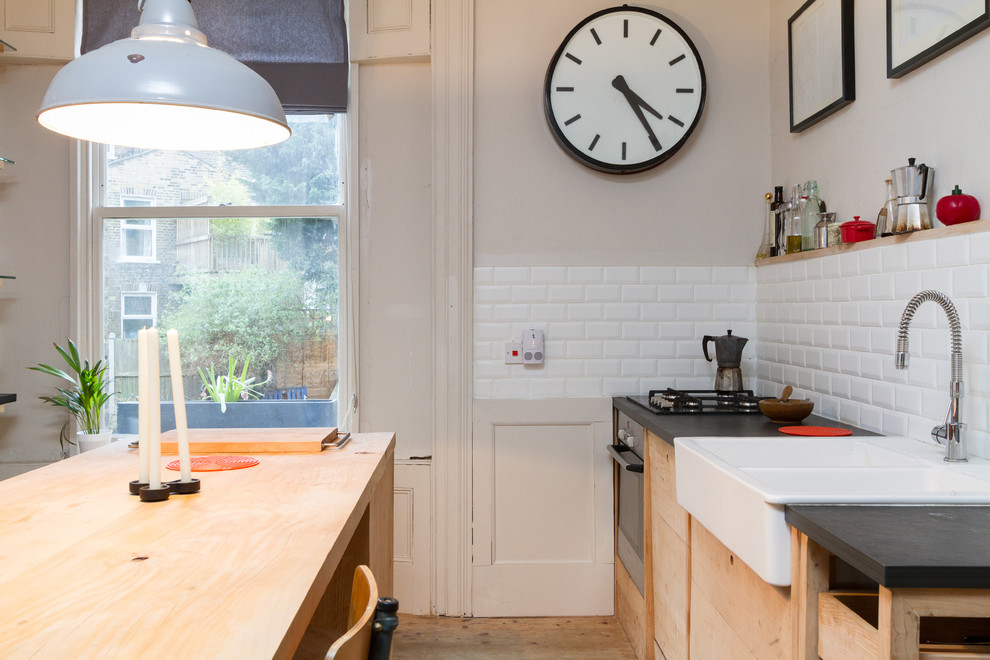 1950s kitchen photo in London with subway tile backsplash and a farmhouse sink