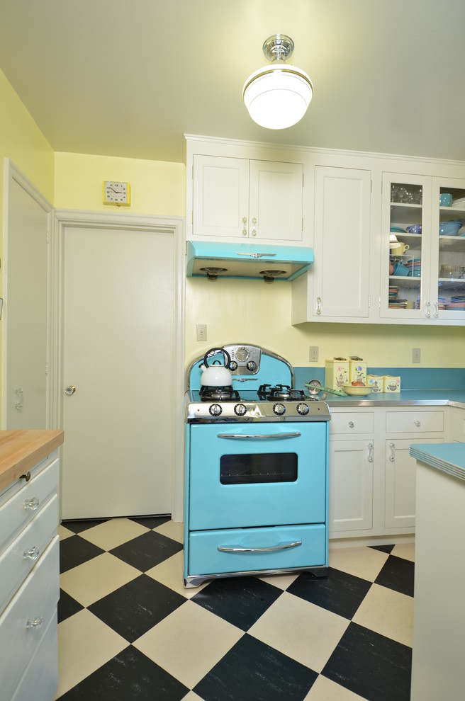 Immagine di una piccola cucina ad U classica chiusa con lavello da incasso, ante in stile shaker, ante bianche, top in laminato, paraspruzzi blu, elettrodomestici colorati e pavimento in linoleum