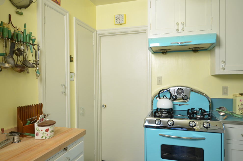 Foto di una piccola cucina ad U chic chiusa con lavello da incasso, ante in stile shaker, ante bianche, top in laminato, paraspruzzi blu, elettrodomestici colorati e pavimento in linoleum